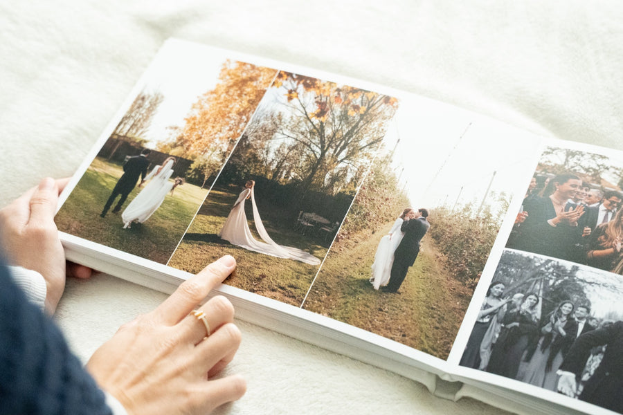 Álbum de boda de Casa Pau abierto por unas páginas con fotos de los novios y de los invitados