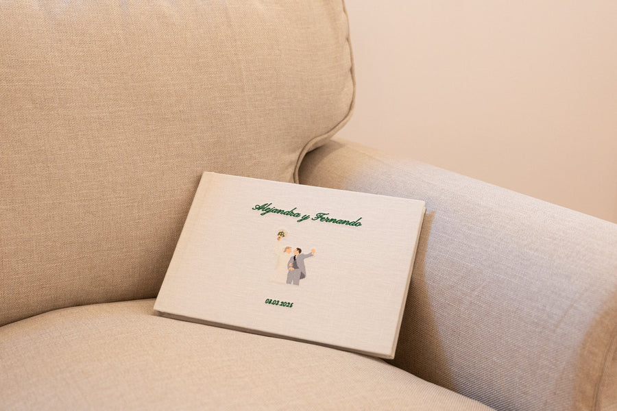 Álbum de boda de lino natural de Casa Pau, cerrado sobre un sofá en casa